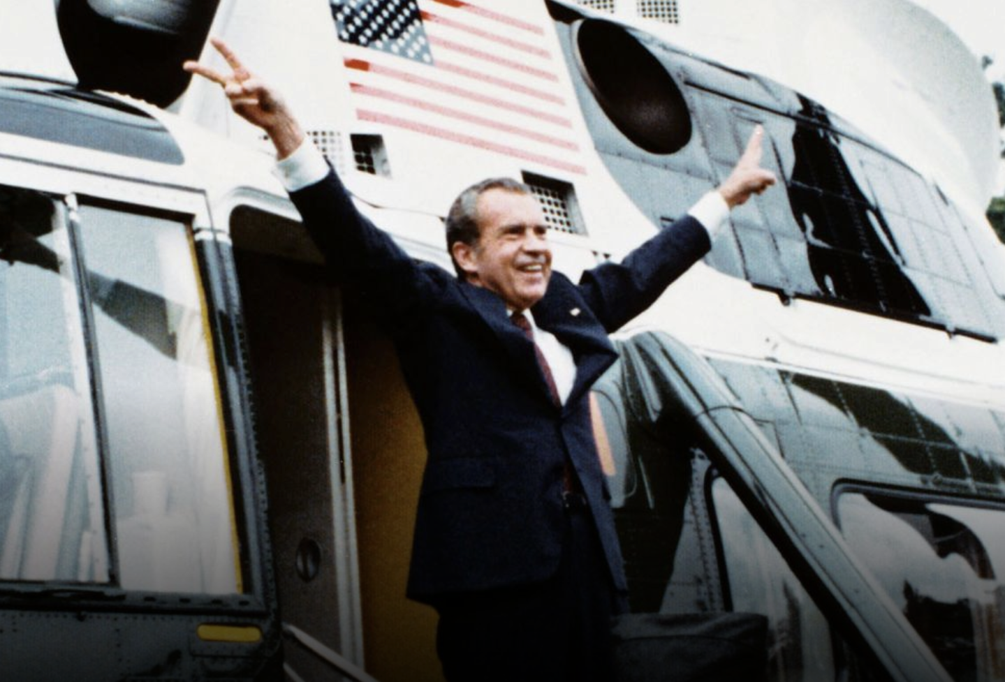 Richard Nixon throwing double peace signs in front of a helicopter